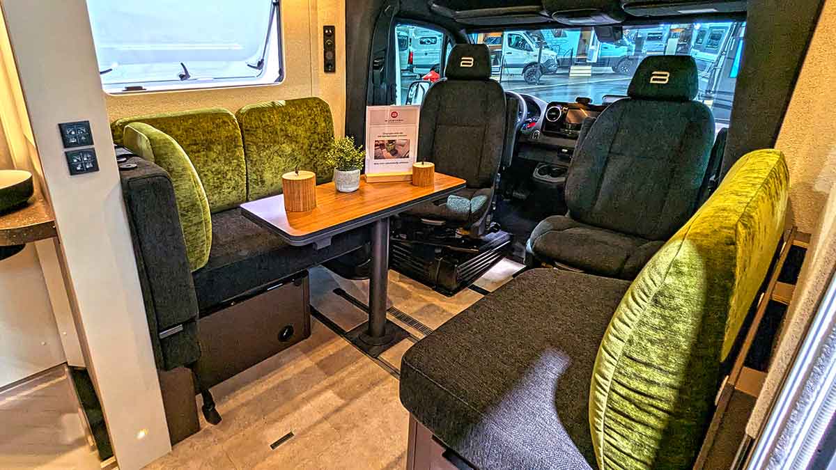 Interieur mit grünen Polstern und eckigem Klapptisch